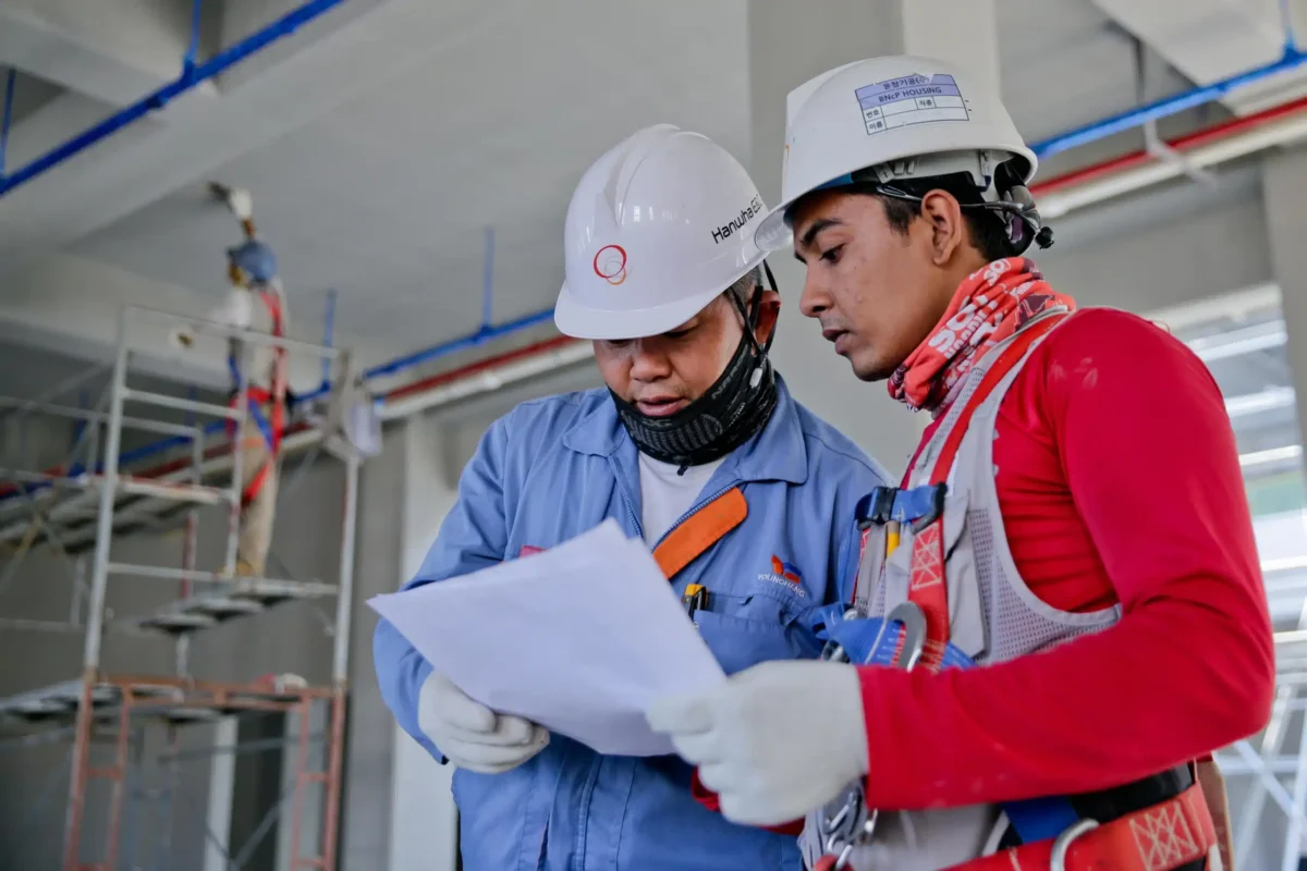 Two construction workers looking at a plan.