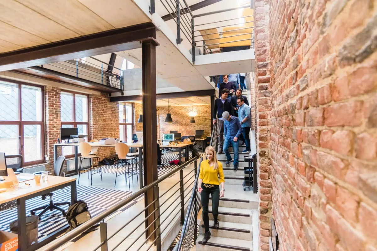 People walking down stairs in an office.