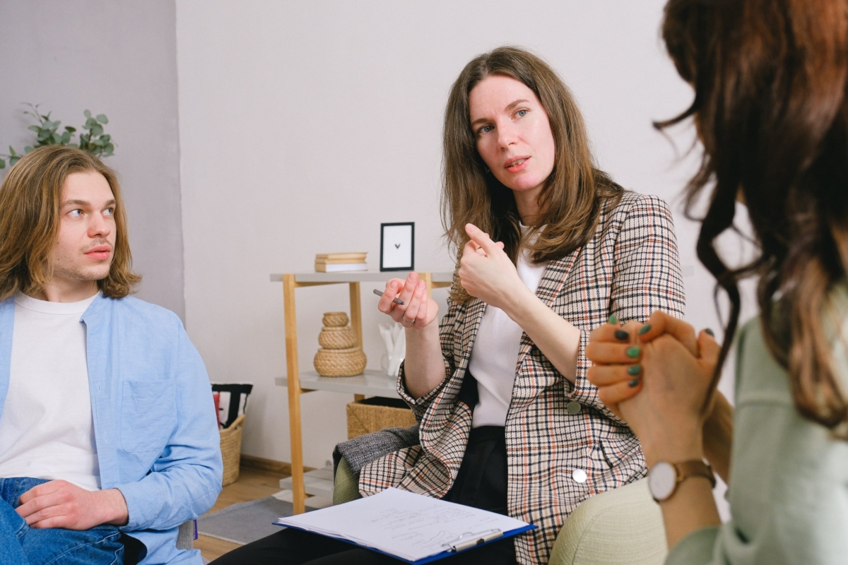 A counsellor talks with a couple in therapy.