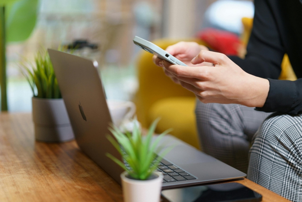 A person on their cellphone and laptop.