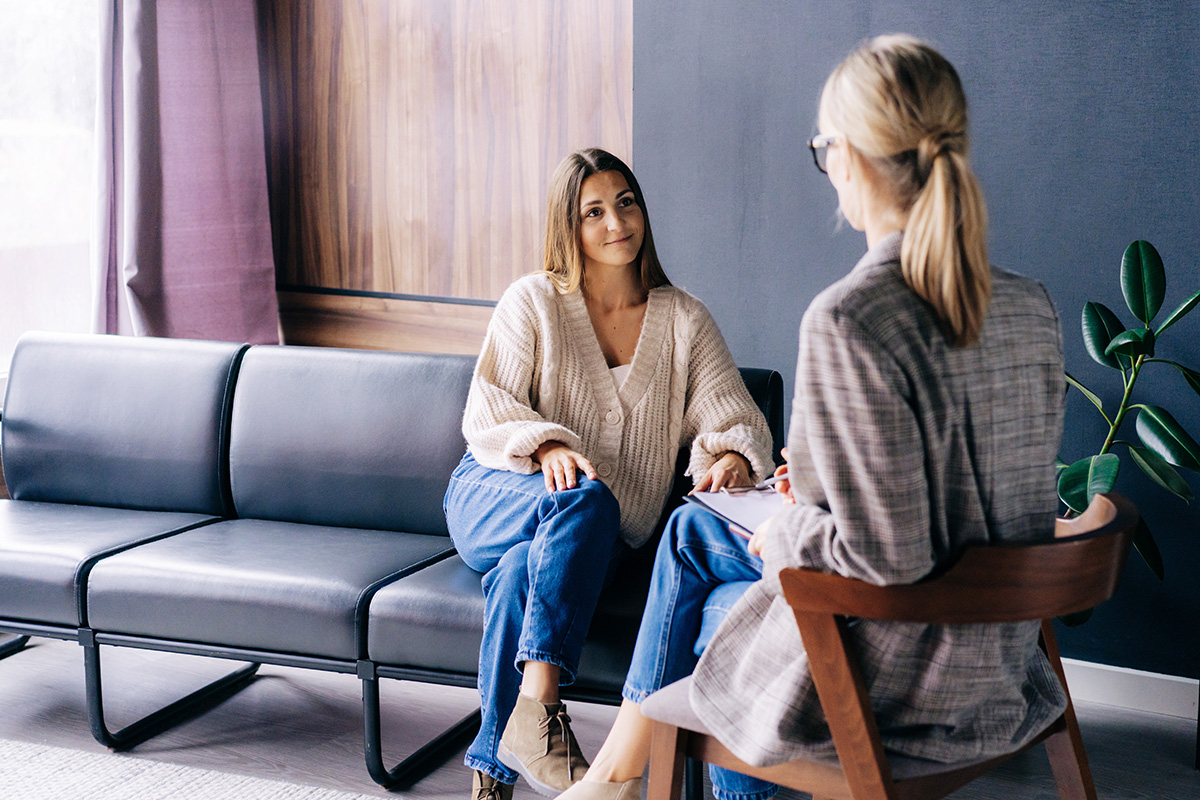 Happy female counselling client in session with female counsellor.